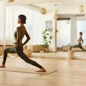 Woman practicing yoga in sunlit studio