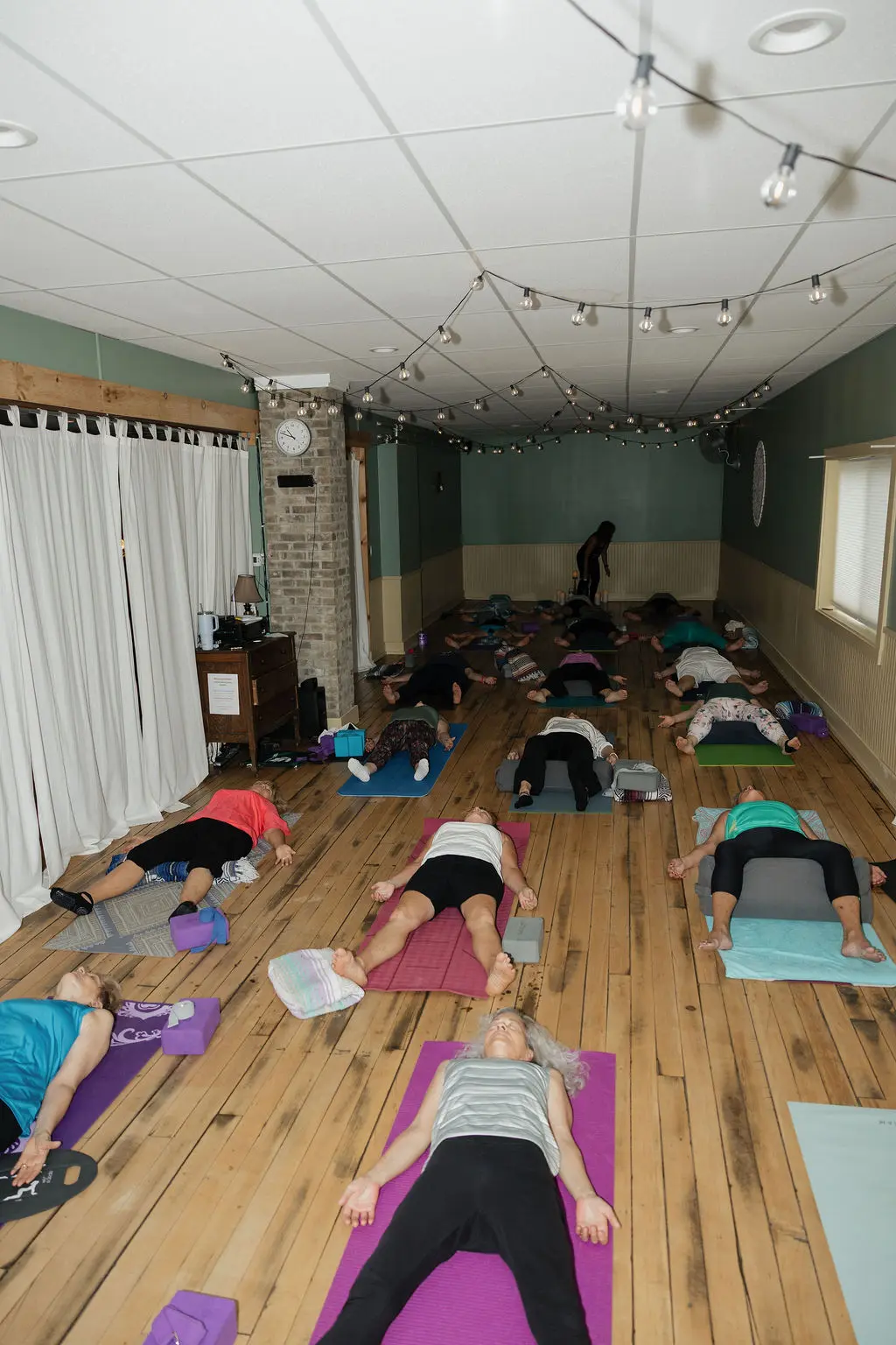 Group practicing yoga in a dimly lit studio.