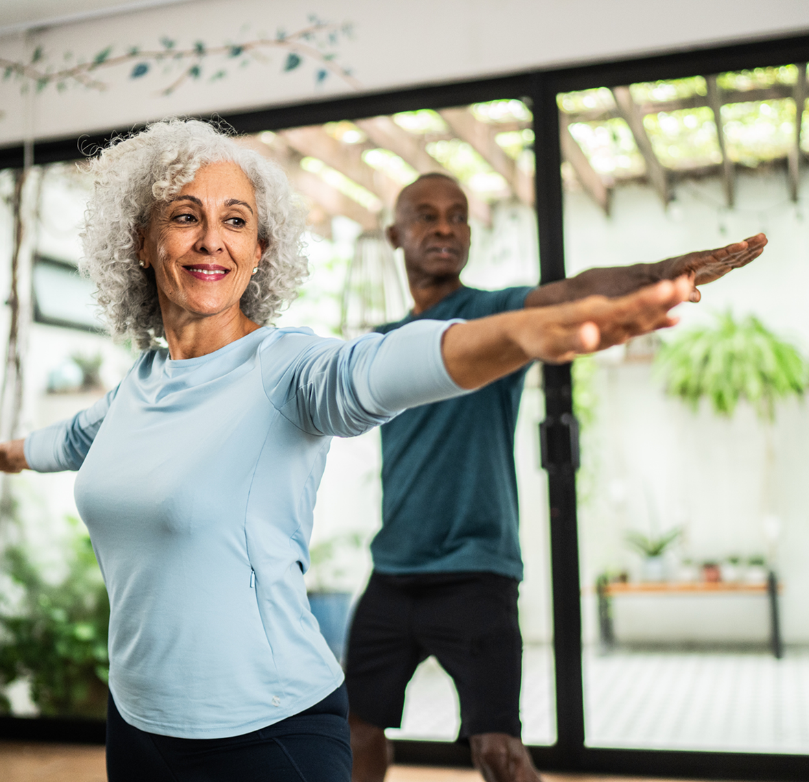 Happy couple in yoga pose at home